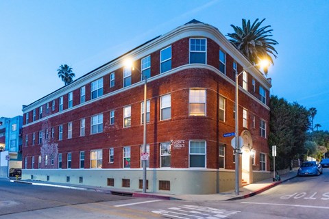 A red brick building with a palm tree in front of it.