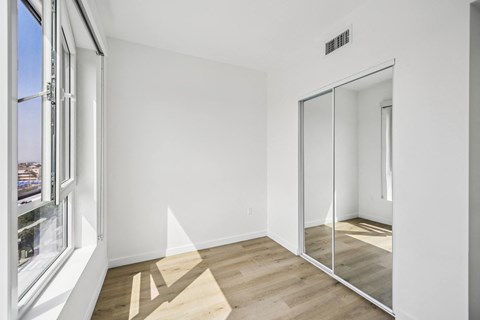A new room with a sliding glass closet door and a vinyl floor with a view of downtown Santa Monica
