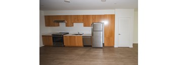 A kitchen with wooden cabinets, white countertop and a stainless steel refrigerator, dishwasher, and stove.