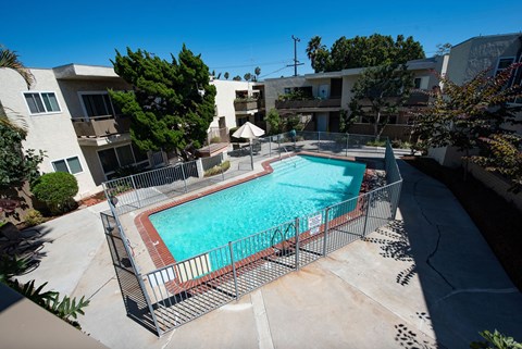 A small pool surrounded by a fence and a metal railing.