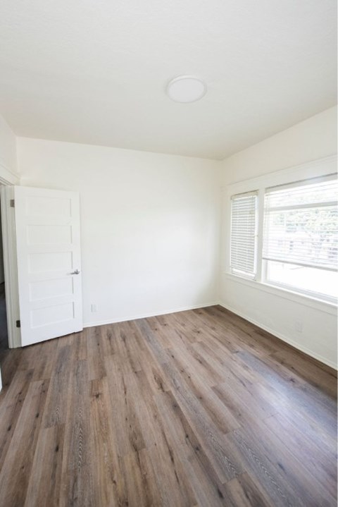 A room with a white door and a window with blinds.