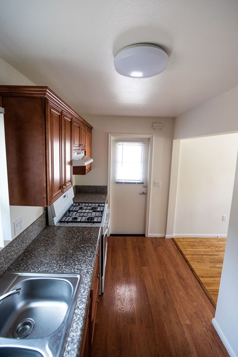 A kitchen with wooden cabinets and a white fridge.