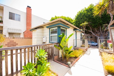 A small house with a green door and a brown fence.