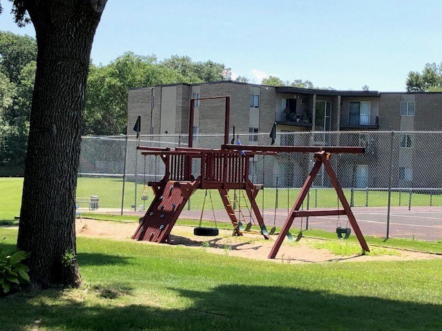 a swing set in a park next to a tree