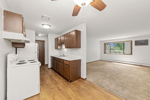 A kitchen with a white stove and wooden cabinets.