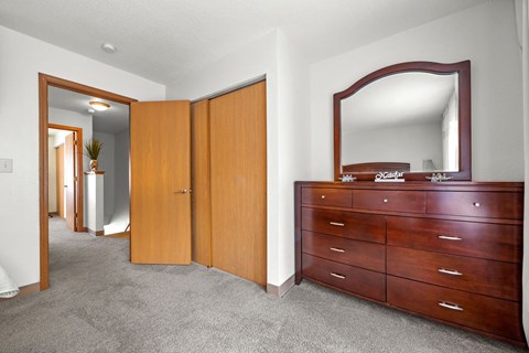 A bedroom with a dresser and mirror.