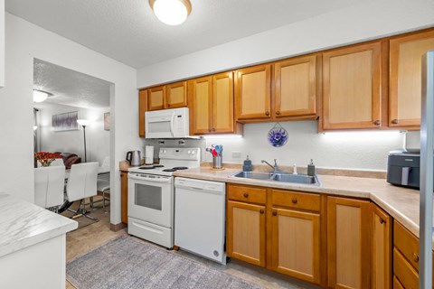 A kitchen with wooden cabinets and white appliances.