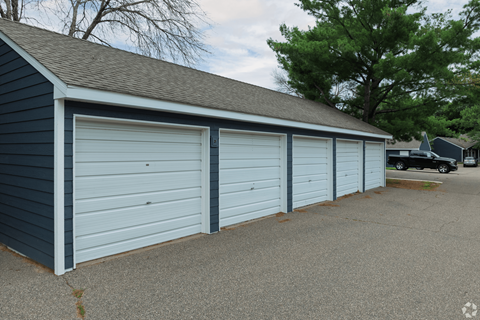 A row of three garage doors in a blue building.