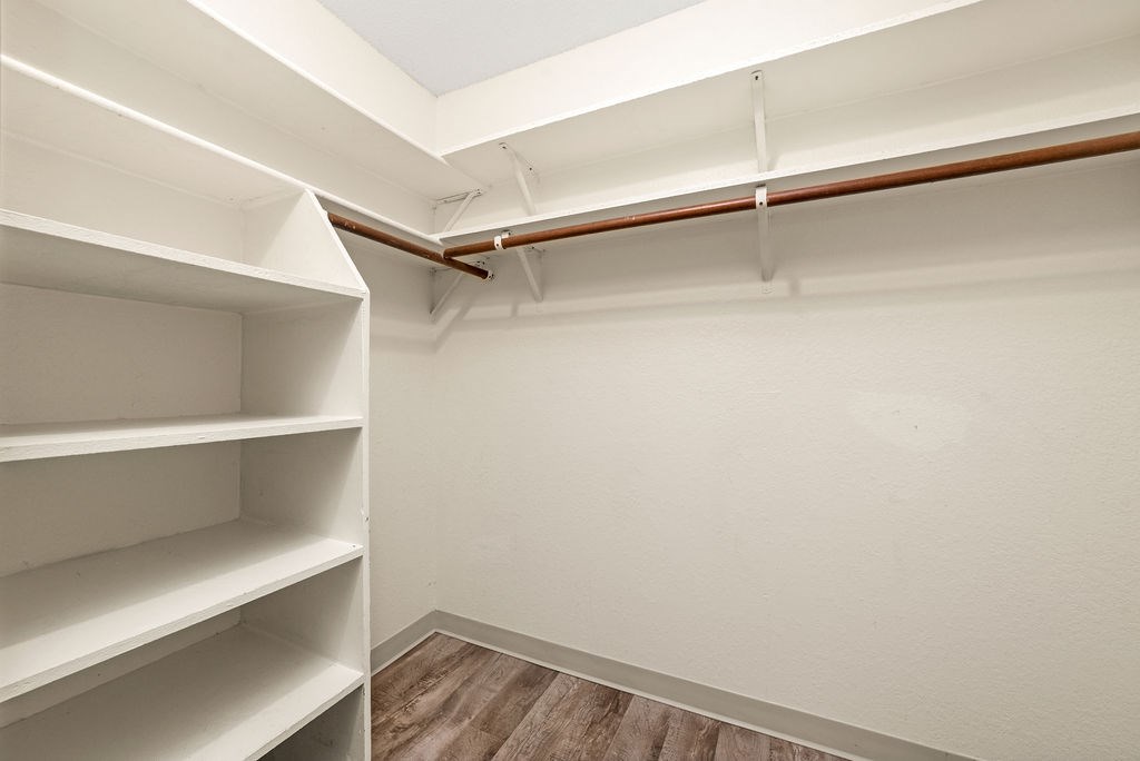Empty white shelves in a room with wooden floors and white walls.