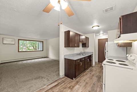 A kitchen with a white stove and wooden cabinets.