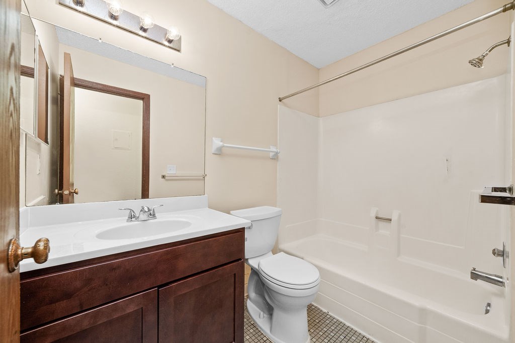 A bathroom with a white sink, toilet, and bathtub.