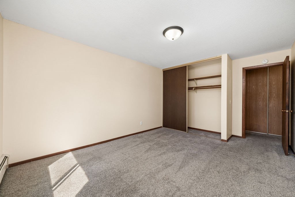 A room with a carpeted floor and a wall-mounted light fixture.