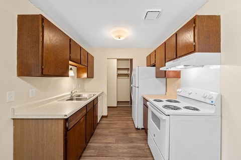 A kitchen with white appliances and wooden cabinets.
