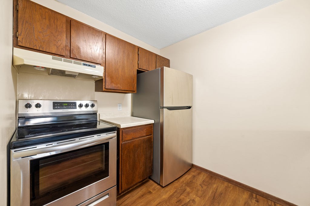 A kitchen with a stove, oven, and refrigerator.