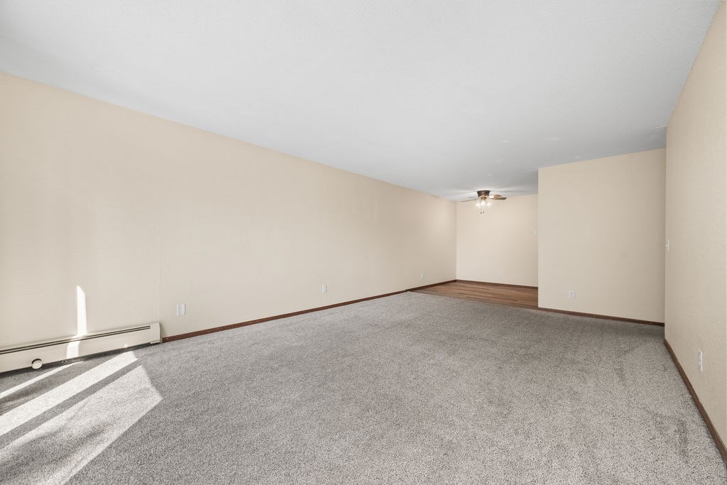 A large empty room with a carpeted floor and white walls.