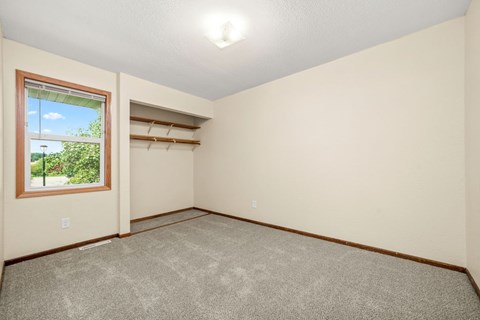 A room with a window and carpeted floor.