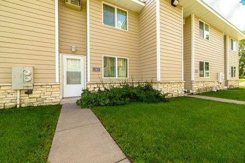 A building with a brown siding and a white door with a window above it.