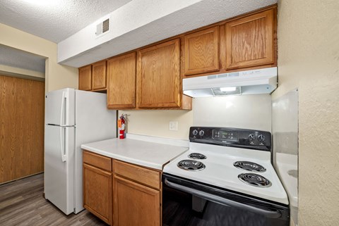 A kitchen with a white refrigerator and a white stove top oven.