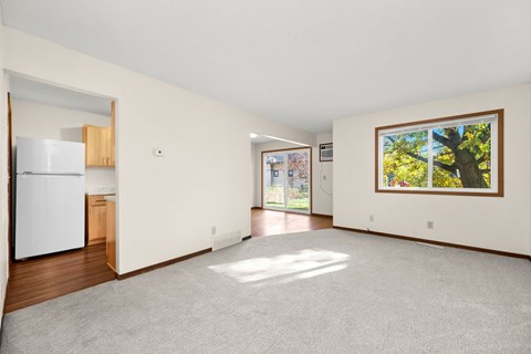 A white refrigerator is in a kitchen with wood cabinets.