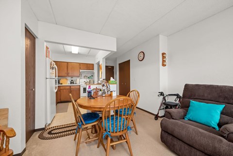 A dining room with a table and chairs.