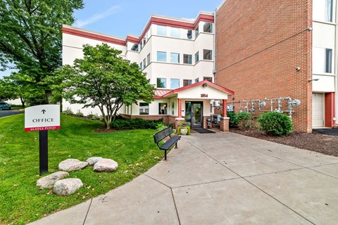 A sign in front of a building that says Office.