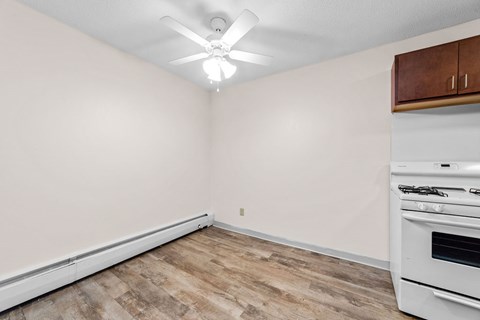 A kitchen with a white oven and wooden cabinets.
