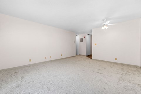 A room with a carpeted floor and a white ceiling with a light fixture.