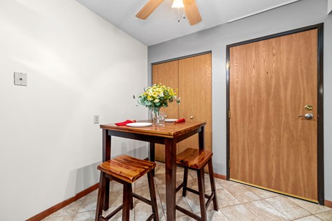A dining room with a wooden table and chairs.