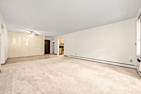 A spacious room with a carpeted floor and white walls.