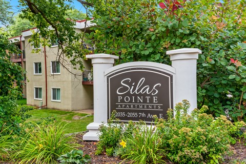 A sign for Dilla's Pointe Apartments stands in front of a building.