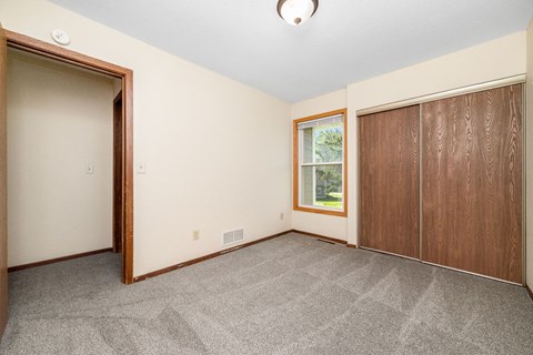 A room with a carpeted floor and a window.