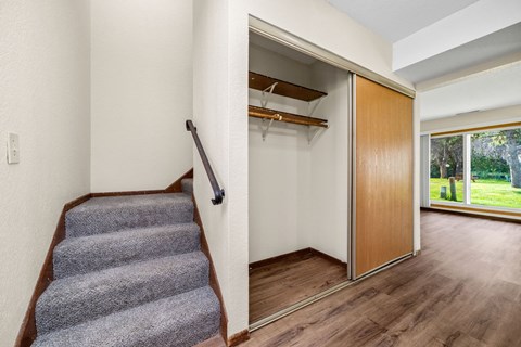 A room with a staircase and a sliding door leading to a balcony.