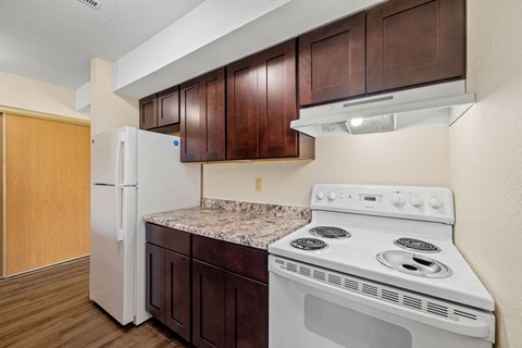 A kitchen with a white stove and white refrigerator.