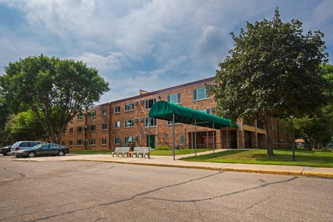 a large brick building with a green canopy in front of it