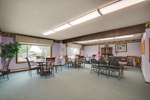 a dining room with tables and chairs and a large window