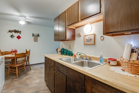 a kitchen with a sink and a dining room with a table