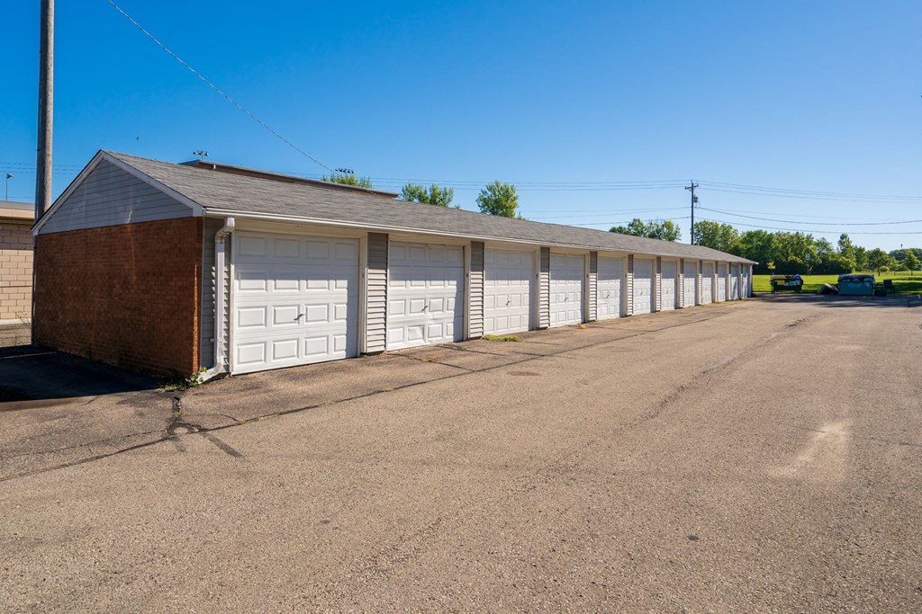 a row of garages with white doors on the side of a building
