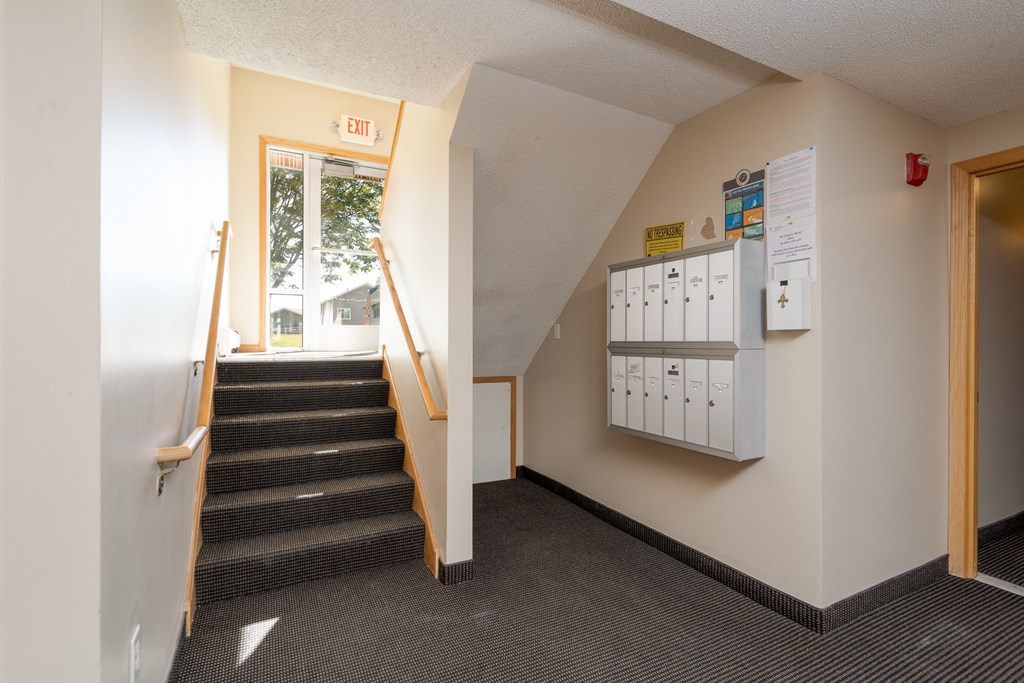 a staircase leading up to a room with a window and a door