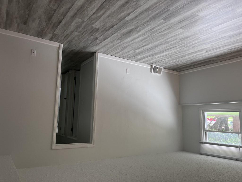 A room with a window and a door on the left side.