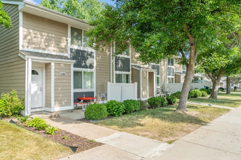 a row of town homes with trees and sidewalks
