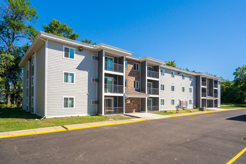 exterior view of an apartment building with a parking lot