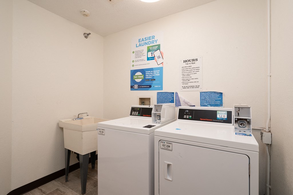 a laundry room with two washing machines and a sink