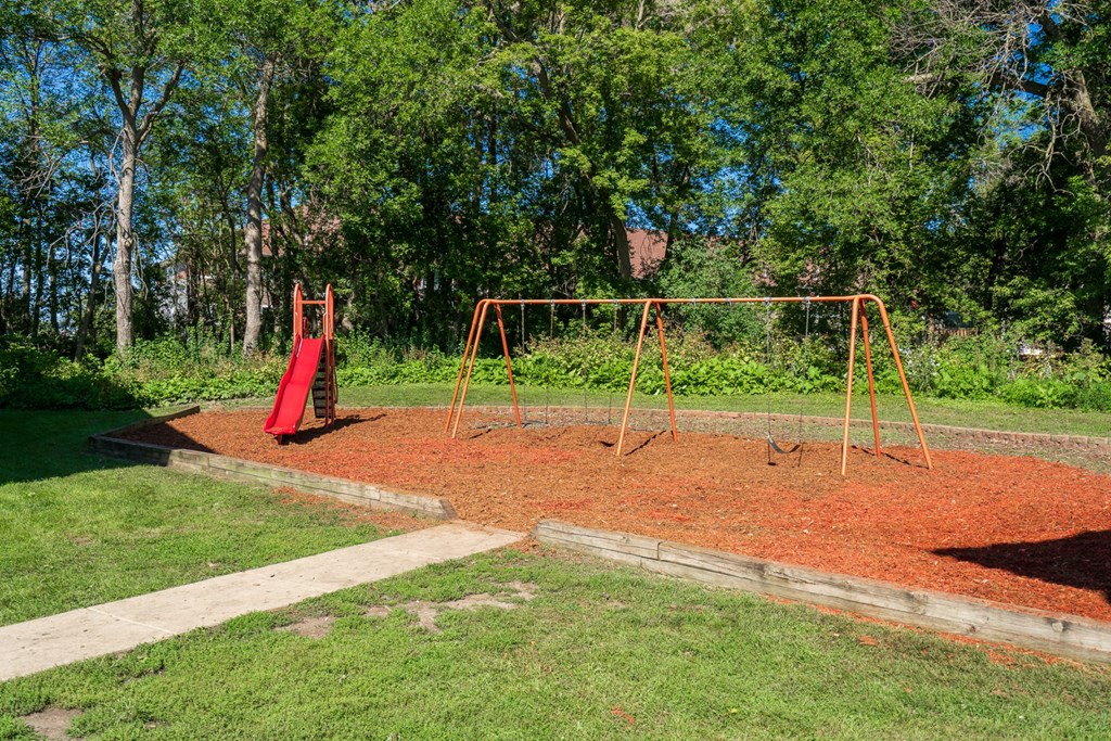 a swing set in a park with trees