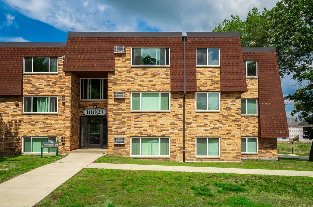the front of a brick building with green windows