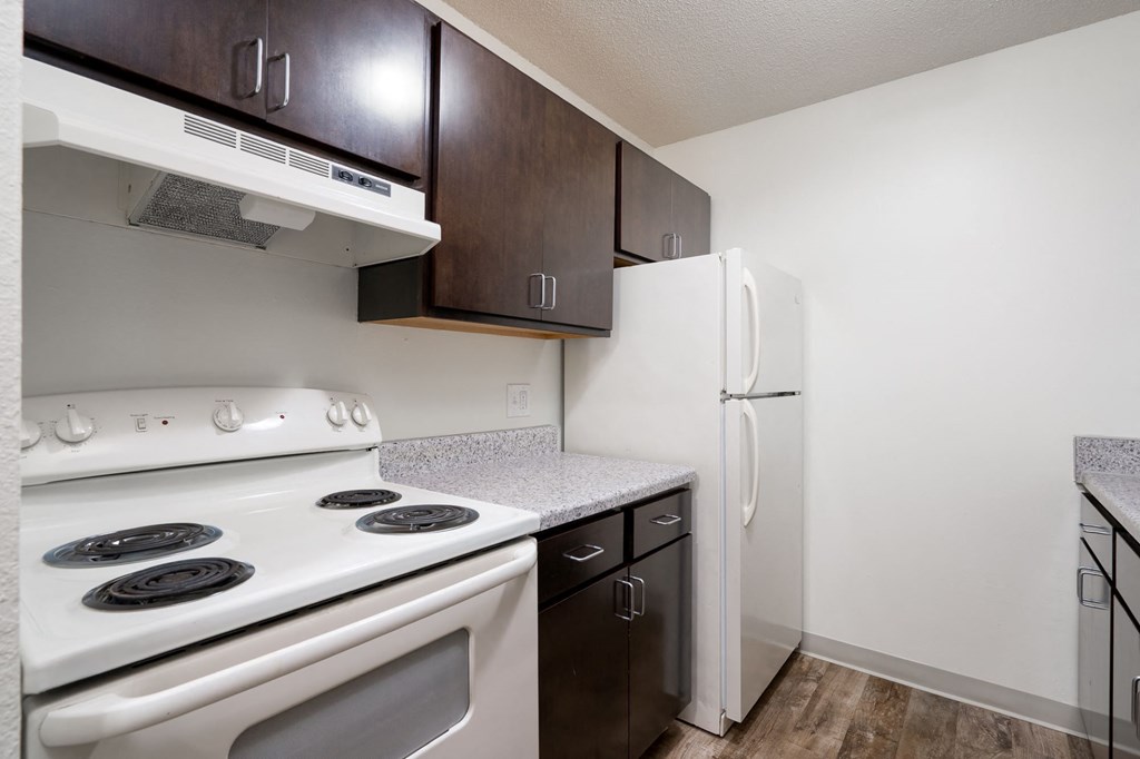 a kitchen with white appliances and wood cabinets and a white refrigerator