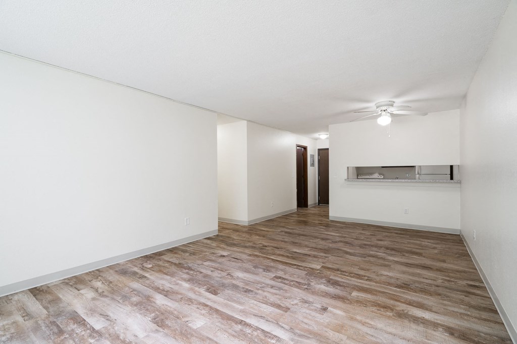 an empty living room with white walls and wood flooring