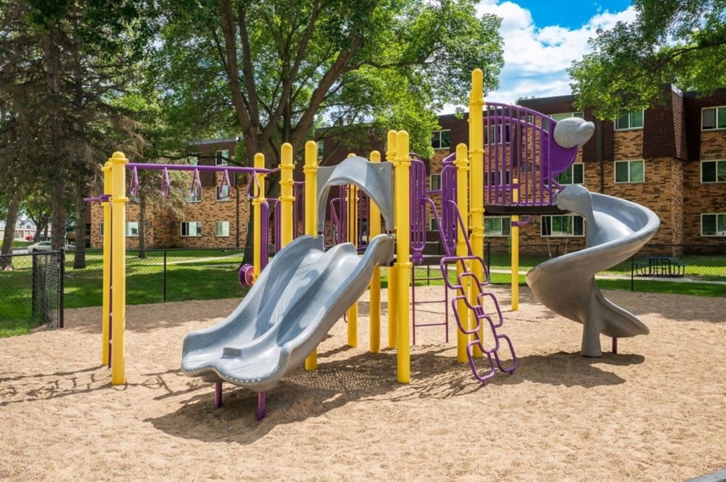 a playground with slides and sand in a park