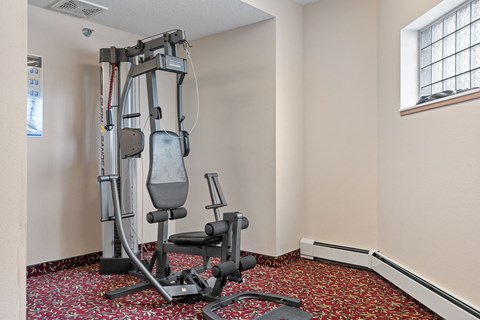 a gym with exercise equipment in the corner of a room