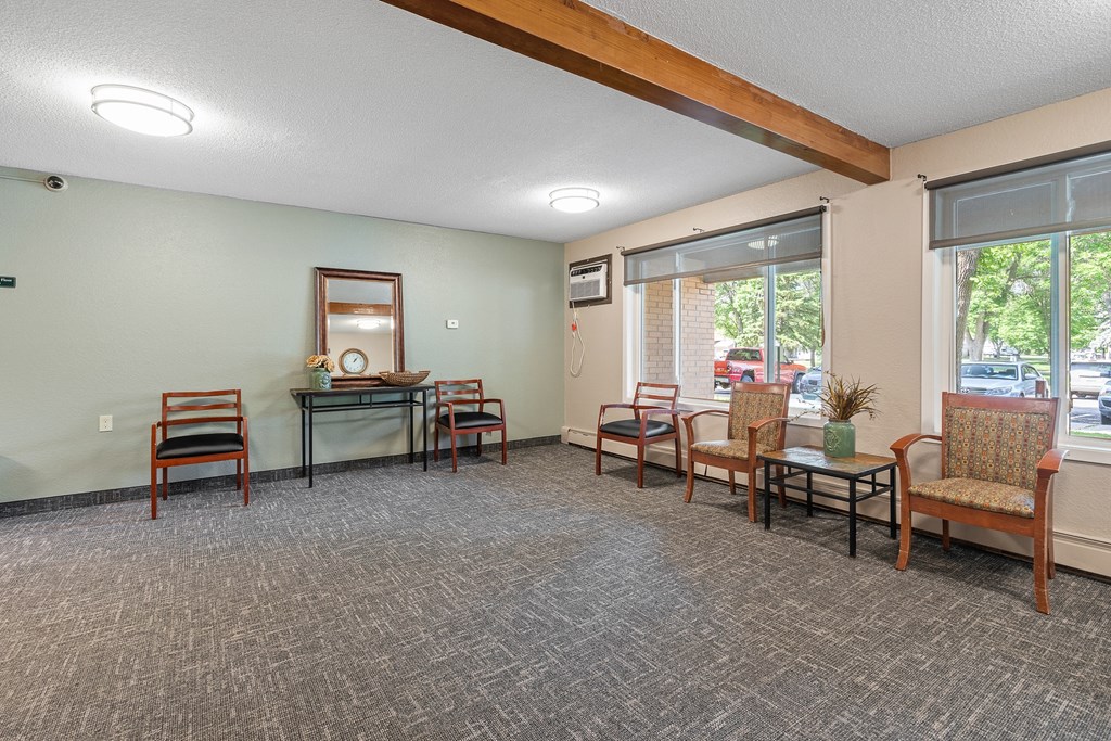 a living room with chairs and tables and a large window