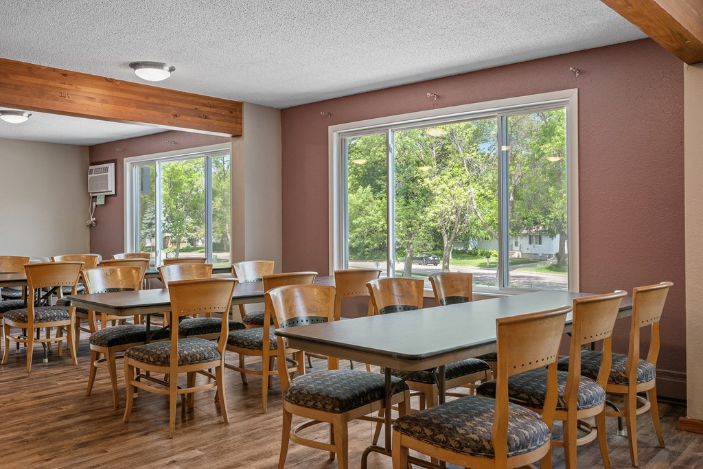 a dining room with tables and chairs and a large window